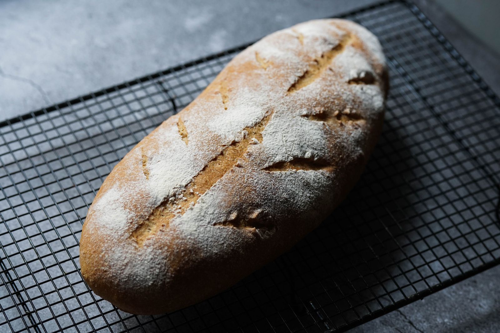 Pão de fermentação natural com casca dourada e pestanas, recém-saído do forno