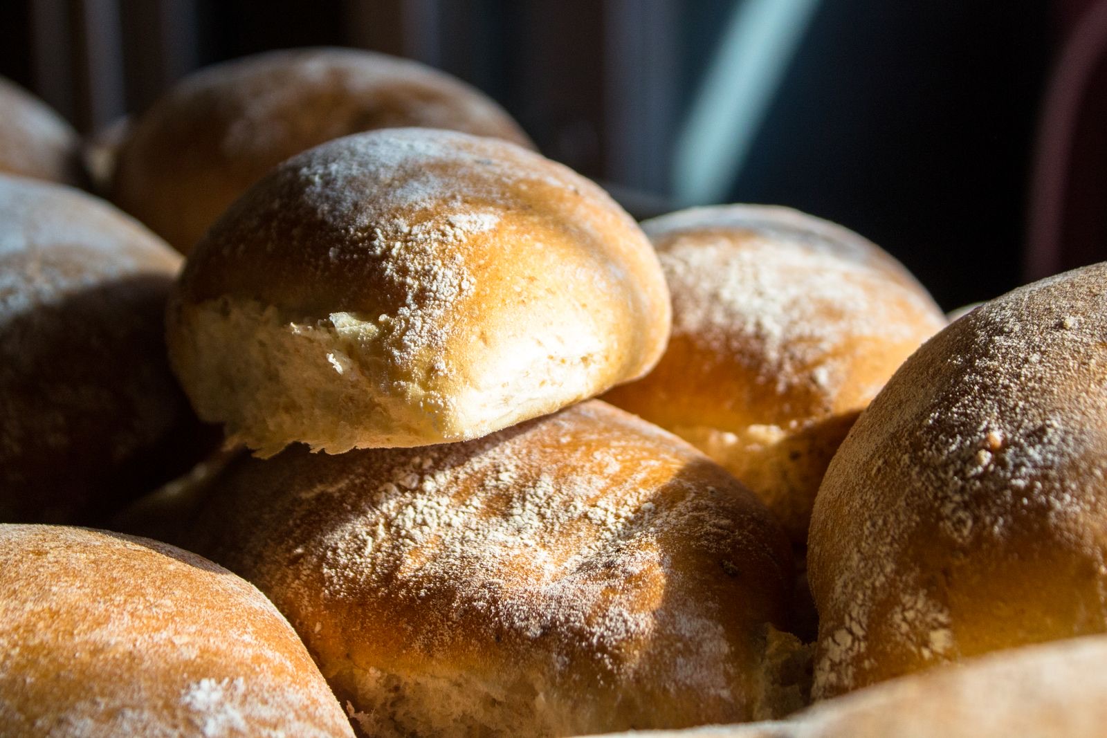 Pães franceses dourados e crocantes, polvilhados com farinha, sob a luz da manhã